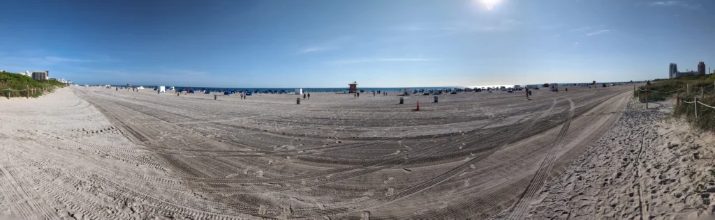Panoramablick über den breiten Sandstrand von South Beach mit Meer und Sonnenschirmen