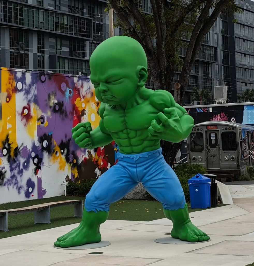 Grüne Baby-Hulk-Statue in Wynwood Miami vor moderner Häuserkulisse
