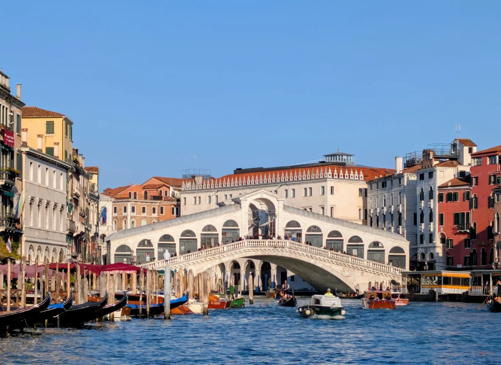 Rialtobrücke über den Canal Grande mit Booten und historischen Gebäuden bei Tageslicht