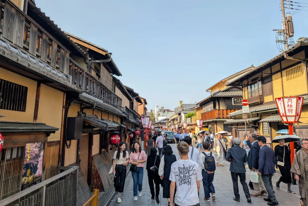 Straße im Gion Viertel in Kyoto mit traditionellen Holzhäusern und Besuchern