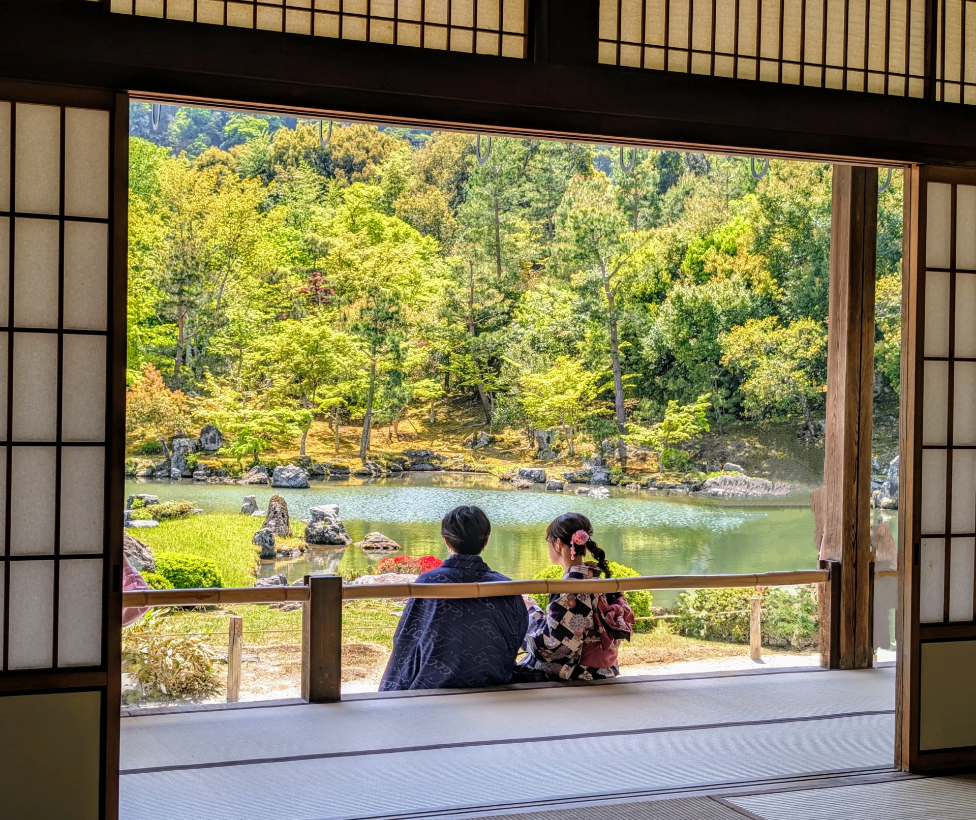 Kyoto mit Kindern – Blick aus einem traditionellen Tempel auf einen japanischen Garten mit sitzendem Paar