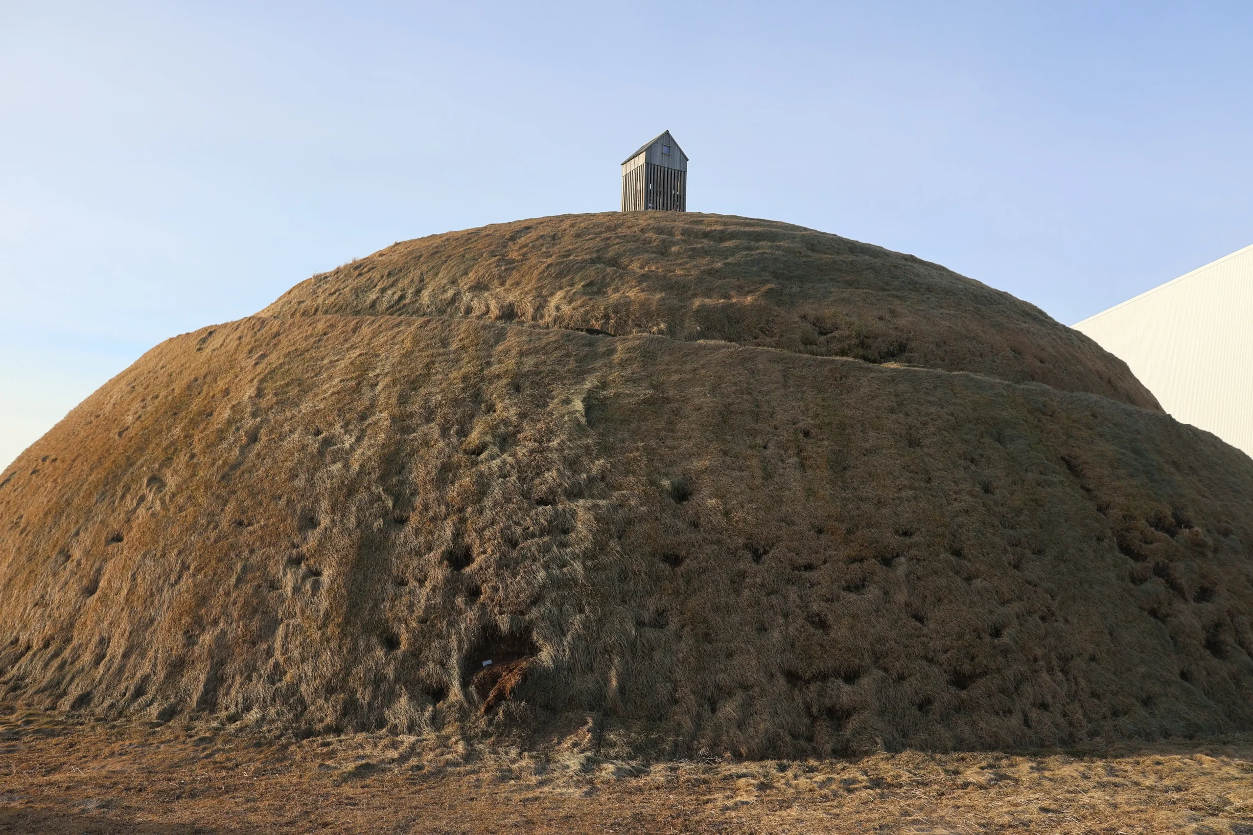 Pufa Huegel in Reykjavik mit kleinem Holzhaus auf der Spitze